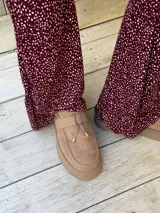 Pantalón oxford de viscosa con estampado de lunares pequeños en color bordó, de talle alto y corte acampanado.