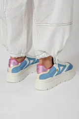 Zapatillas deportivas de cuero color beige, blanco y marrón, con cordones y suela de goma.