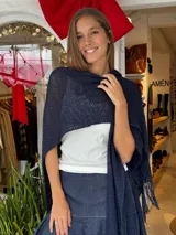 Ruana Clara tejida a mano con hilo liviano, de color azul marino, con diseño abierto y flecos en los extremos.