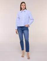 Camisa de algodón celeste con patrón de milrayas finas y aplicaciones florales en relieve deshilachado en el frente. Cuenta con cuello camisero tradicional, cierre frontal con botones, mangas largas con puños abotonados y corte semi holgado.