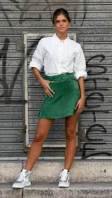 Camisa violeta con cuello clásico adornado con apliques florales y colgantes de perlas. Mangas largas abullonadas con puños abotonados. Diseño anudado en la parte delantera.