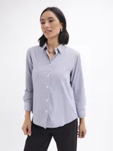 Camisa de corte clásico con estampado de rayas verticales finas en color azul y blanco, cuello camisero y cierre frontal con botones.