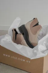 Bota tipo chelsea de punta redonda, confeccionada en una combinación de cuero texturizado y gamuza en tonos marrones. Presenta elásticos laterales negros y una suela track robusta de goma negra.