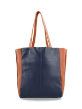 Cartera tipo tote bag de cuero, con diseño bicolor en azul marino y tostado, asas largas para el hombro y costuras reforzadas.
