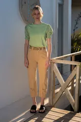 Pantalón de jean color beige, de tiro alto, corte recto y largo a media pierna con ajuste en el bajo.