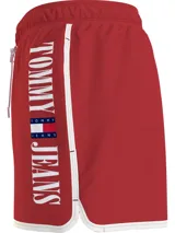 Short de baño rojo de poliéster reciclado con cintura elástica ajustable con cordón blanco, logo de Tommy Jeans estampado verticalmente en el lateral y ribete blanco en el ruedo.