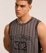 Musculosa deportiva de básquet gris con rayas verticales negras, cuello redondo y sisas con ribete negro. Estampado frontal con la palabra "Chicago" y el número "32".