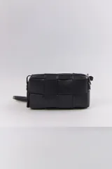 Bandolera rectangular negra con diseño trenzado y correa fina al hombro.