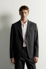 Blazer slim fit de corte estructurado color gris oscuro, confeccionado en tejido con viscosa, con solapas de muesca, bolsillos con solapa en la cadera y cierre frontal de un botón.