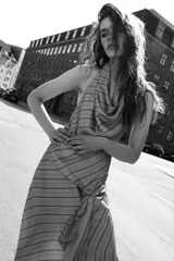 Vestido midi de satén con cuello halter y escote drapeado. Presenta un diseño a rayas diagonales y detalle de volantes en el frente.