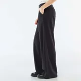 Pantalón de corte ancho y tiro medio, color negro, con detalle de cintura elástica visible estilo bóxer y bolsillos laterales.