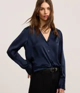 Camisa de satén azul marino, con cuello inglés, manga larga y cierre frontal con botones.