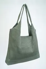 Bolso tipo tote bag de tela color verde oliva con textura acanalada.