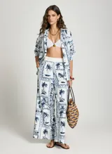 Pantalon ancho de tiro alto de Le Lis Blanc con estampado de palmeras y motivos tropicales en azul y blanco.