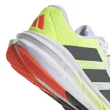 Championes de running Adidas Questar 3, con diseño técnico en malla transpirable color blanco, detalles en verde lima y franjas laterales en gris oscuro. Cuenta con entresuela amortiguada y suela de goma resistente.