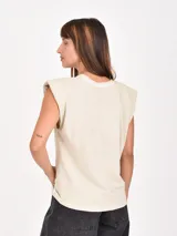 Remera sin mangas de corte recto, color negro, con hombreras y detalle de strass aplicado en la parte superior delantera.