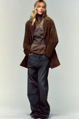 Top bustier corsetero color gris oscuro, con escote recto, solapa y hombros descubiertos. Presenta falsos botones forrados a tono en el frente y cierre lateral con cremallera oculta.