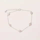 Pulsera plateada con cadena fina y cinco dijes circulares incrustados con cristales brillantes. Cuenta con cierre de mosquetón y cadena de extensión.