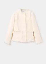 Chaqueta de tweed color crema con cuello redondo, cierre frontal con botones y dos bolsillos de parche delanteros. Presenta terminaciones deshilachadas y forro interior.
