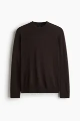 Buzo de punto fino color marrón oscuro, con cuello redondo y remates acanalados en cuello, puños y bajo.