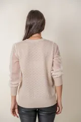 Cárdigan color beige con botones de strass, cuello de tul y mangas de plumeti.