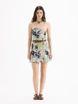 Vestido corto de silueta strapless y calce ajustado, confeccionado en encaje estampado con diseño floreado sobre base amarilla. Está forrado íntegramente en poplín y presenta recortes de entalle en el delantero y la espalda.