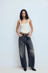 Top estilo corset de color blanco con escote cuadrado y tirantes anchos. Presenta paneles laterales y centrales con tejido drapeado, estructura entallada y cierre posterior con cremallera.