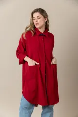 Camisa larga color rojo, de seda poliéster, con cuello clásico, cierre frontal con botones, mangas largas y bolsillos grandes.