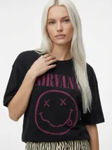Camiseta negra de algodón orgánico con cuello redondo y mangas cortas. Estampado frontal con el logo de la banda Nirvana: el nombre en color magenta y el icónico smiley con ojos en 'x' y lengua afuera, también en magenta.