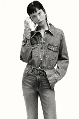 Jean de tiro alto con corte acampanado desde la rodilla, confeccionado en denim con leve elasticidad. Presenta diseño clásico de cinco bolsillos, cierre frontal con cremallera y botón metálico.