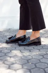 Mocasines negros charol con detalle de borlas en el empeine.