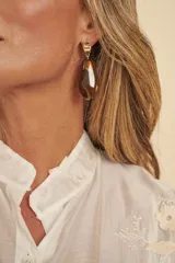 Aros colgantes con base metálica dorada y piedra acanalada en tonos marrones tipo carey.