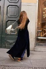 Tapado largo de terciopelo azul marino con frunce a la altura de la cadera y tajos en los costados.