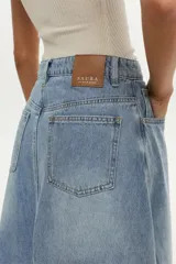 Falda midi de denim celeste con diseño de paneles y tajo frontal.