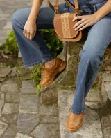 Zapato acordonado estilo oxford de cuero vacuno en color plateado metalizado, con diseño brogue, suela de goma y taco de madera.