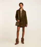 Campera trucker color verde oliva confeccionada en sarga de algodón, con cuello inglés, manga larga, bolsillos delanteros con solapa y abotonado delantero.