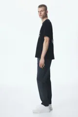 Pantalón de vestir gris oscuro, corte slim fit, con bolsillos laterales y traseros. Cierre frontal con botón y cremallera.