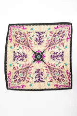 Bandana cuadrada con estampado paisley en tonos violeta, fucsia, negro y beige.