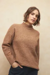 Sweater color marrón de tejido de punto, con cuello alto y mangas largas.