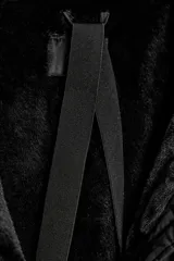 Anorak acolchado negro resistente al agua y al viento, con cuello subido y capucha con pelo sintético en tono tostado a contraste. Cuenta con manga larga, bolsillos delanteros con cierre, cinturón elástico ajustable con hebilla metálica y cierre frontal con cremallera y botones a presión ocultos.