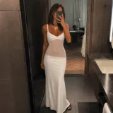 Vestido largo blanco de tirantes, con diseño ajustado al cuerpo y sección transparente en la zona del torso.