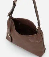 Cartera mediana tipo hobo de Satinato, confeccionada en poliuretano con textura granulada y diseño geométrico sutil. Cuenta con cierre superior de cremallera, correa de hombro ajustable y un dije decorativo metálico con forma triangular.