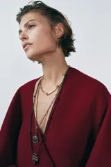 Gargantilla de metal dorado compuesta por una cadena de eslabones tubulares alternados con esferas lisas, con cierre de mosquetón ajustable.