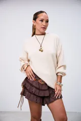 Sweater de punto color beige, con cuello redondo y mangas largas abullonadas, de corte holgado.