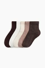 Pack de cinco pares de medias tobilleras de punto acanalado suave, con borde superior elástico en tonos neutros.
