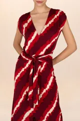 Vestido largo con estampado de rayas rojas, bordó y crema, con escote en V, mangas cortas y lazo en la cintura.
