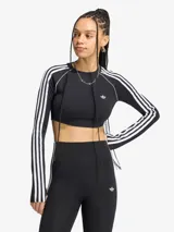 Playera corta Adidas Originals de manga larga, color negro con las tres franjas características en color blanco a lo largo de las mangas y el logo del trifolio bordado en el pecho.
