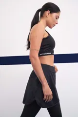 Calza capri negra con falda corta superpuesta.