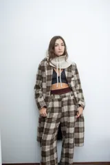 Chaqueta de corte sastre con estampado de cuadros en tonos marrones y beige, con solapas clásicas y cierre frontal con botones.