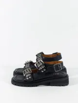 Sandalias negras de cuero con plataforma y hebillas plateadas ajustables en el empeine y el tobillo.